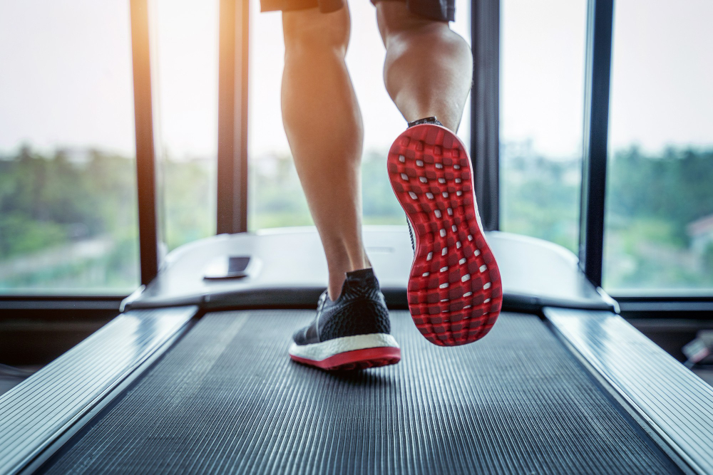 Quais são os melhores aeróbicos para fazer na academia? 4 pes masculinos de tenis correndo na esteira na academia conceito de